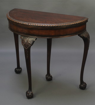An Edwardian Chippendale style demi-lune card table with gadrooned borders, raised on carved cabriole, ball and claw supports 30"h x 33"w x 16"d 
