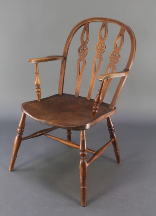 An elm and beech wheel back carver chair with triple wheel back and solid elm seat, raised on turned supports with H framed stretcher 