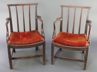 A pair of Georgian mahogany stick and bar back carver chairs with upholstered drop in seats, raised on square tapered supports with X framed stretchers 