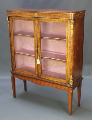 A Victorian figured inlaid walnut display cabinet with gilt metal mounts, fitted shelves enclosed by glazed panelled doors and raised on an associated walnut base with square tapered supports 52"h x 41 1/2"w x 13"d 