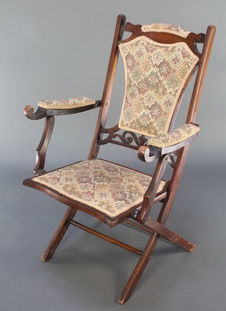 A Victorian folding mahogany campaign chair, the seat back and arms upholstered in tapestry material  