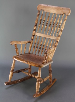 A Victorian bleached elm spindle back rocking chair with solid seat and H framed stretcher