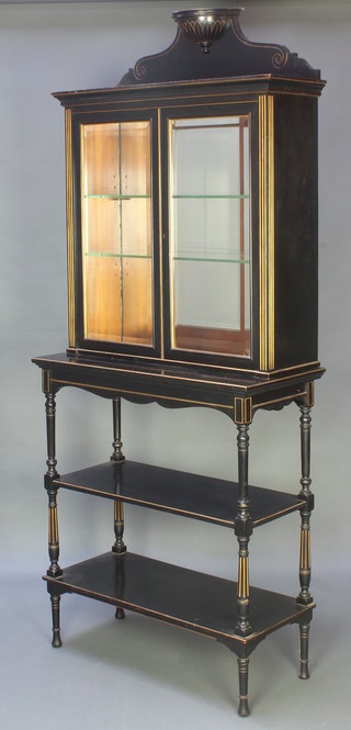 A Victorian ebonised and gilt display cabinet, the upper section with raised back, the interior with  mirrored back, fitted adjustable shelves enclosed by bevelled glazed panelled doors, the base fitted 2 undertiers, raised on turned supports 76"h x  32"w x 15"d