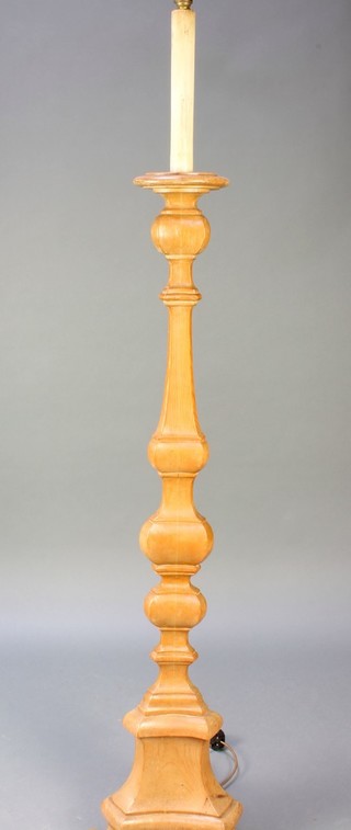 A pine Rococo style standard lamp in the form of an altar candlestick 63", raised on a triform base with scroll feet 