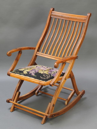 An Edwardian walnut stick back rocking campaign chair 