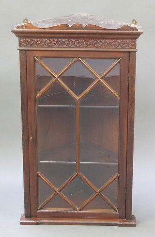 An Edwardian Chippendale style mahogany corner cabinet with moulded cornice and blind fret work frieze, fitted shelves enclosed by astragal glazed panelled doors, 29 1/2"h x 17"w x 12"d 