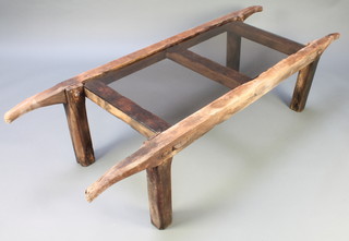 A rectangular elm and smoked plate glass coffee table, formed from trestles 17"h x 68"w x 24"d 