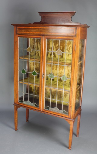 An Edwardian Art Nouveau inlaid mahogany display cabinet with raised back, fitted plush lined shelves enclosed by lead glazed panelled doors, raised on square supports 63 1/2"h x 34 1/2"w x 14 1/2d 