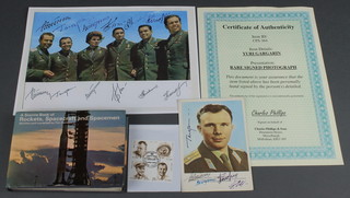 Yuri Gagarin, a signed colour postcard 6" x 4" together with a Charles Phillips & Sons certificate of authenticity, a collection of facsimile signatures of Russian astronauts, 1 volume Tim Furniss - A Source Book of Rockets, Space Craft and Spacemen
