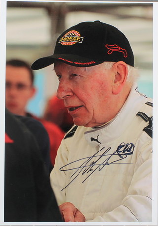 John Surtees, a signed colour photograph of John Surtees wearing a baseball cap 