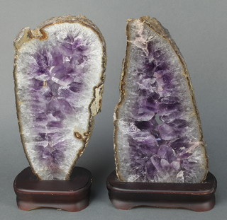 2 shaped and polished sections of amethyst 13" x 6" and 12" x 6", raised on wooden bases 