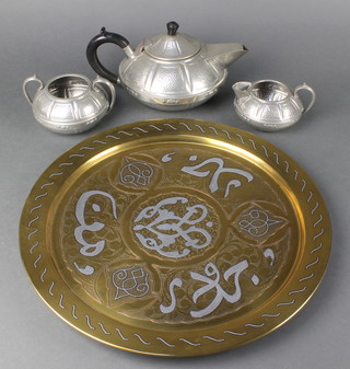 A Craftsman's planished pewter 3 piece tea service with teapot, twin handled sugar bowl and cream jug and a brass and white metal charger 15 1/2" diam. 
