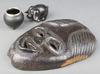 A carved African mask 8", a resin figure of a pig 1" and a pottery salt in the form of a sword with silver mount 1" 