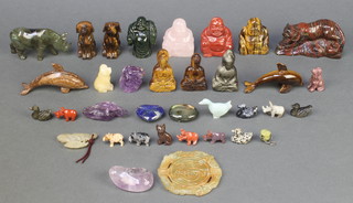 A carved hardstone figure of a standing tiger 2 1/2" x 4" x 2", a circular green carved hardstone pendant 3", a carved section of amethyst in the form of a toad 1 1/2" and 1 other 3", an amethyst pebble 2", 6 carved hardstone figures of Buddhas, do. Rhino, 2 do. dogs, do. dolphins, a cauldron and 16 miniature carved hardstone figures and 2 sections of carved hardstone

