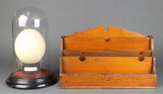 An ostrich egg 4 1/2" (cracked) contained under a glass dome  together with a wooden letter rack 