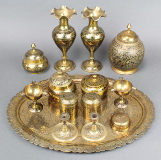 An oval Indian engraved brass tray 20" x 15", a pair of Benares brass vases 10", ditto jar and cover 8" and a collection of Benares brassware 