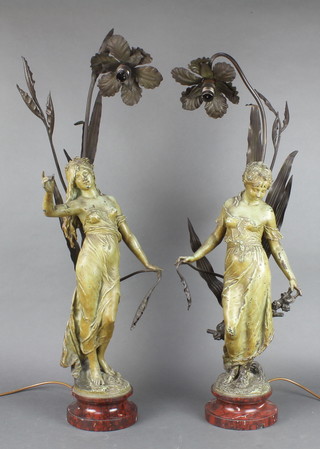 A pair of Art Nouveau bronze lanterns in the form of standing girls having reeds, raised on polished marble bases 32"h x 5 1/2" diam. 
