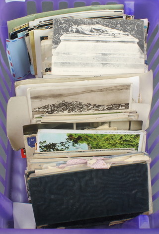 A collection of black and white and coloured postcards and a small stock book of stamps and loose stamps 