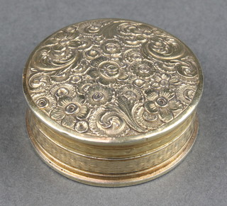 A George IV silver gilt circular pill box decorated with flowers London 1823 1 1/4", 10 grams 