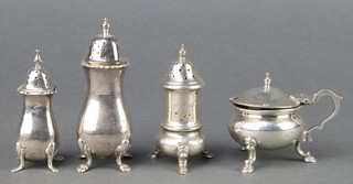 A silver mustard with S scroll handle and pad feet, London 1922 and 3 pepperettes 208 grams 