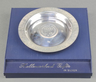 A silver dish with bark finish rim inset a coin Sheffield 1973, 134 grams, boxed