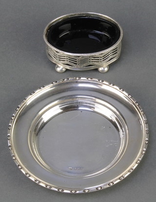 A circular silver dish with fancy rim Sheffield 1965 together with an oval silver pierced mustard with blue glass liner 124 grams