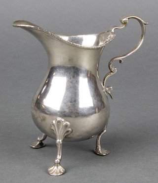 A George III silver cream jug of baluster form with S scroll handle on shell feet, rubbed date letters 136 grams 