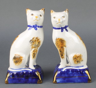 A pair of Staffordshire style figures of cats sitting on cushions 8" 