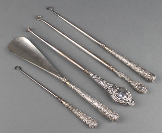 A silver handled shoe horn and 4 ditto button hooks with rubbed marks