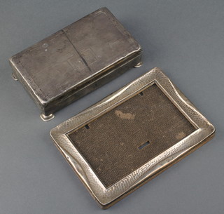 A rectangular hammered pattern silver photograph frame Birmingham 1917 6 1/2" x 4 3/4" and a silver engine turned cigarette box 