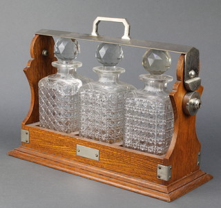 An Edwardian oak and silver plated mounted 3 bottle tantalus 14 1/2" 