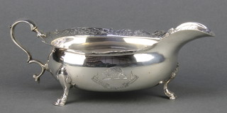 A George II silver sauce boat with chased armorial and floral and shell rim on hoof feet, Edinburgh 1746, 192 grams 7 1/2" 