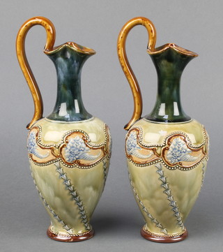 A pair of Royal Doulton ewers, the green and blue ground with floral cornucopia 9 1/2" 