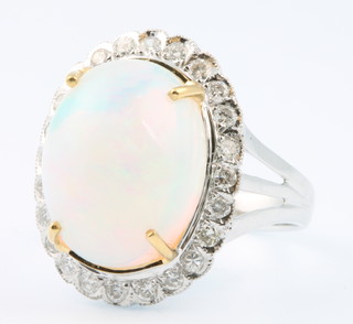 An 18ct white gold oval opal and diamond cluster ring the centre stone approx. 6.28ct surrounded by brilliant cut diamonds approx. 0.52ct, size N 