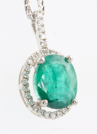 An 18ct white gold emerald and diamond oval pendant, the centre stone approx 2.56ct surrounded by brilliant cut diamonds approx 0.23ct 