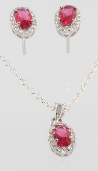 A silver and cubic zirconia pendant and earring set with pink stones
