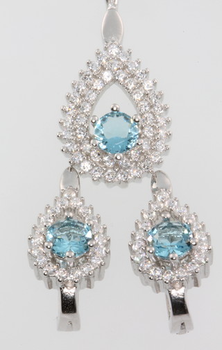 A cubic zirconia pear shaped pendant and earrings set with pale blue stones 