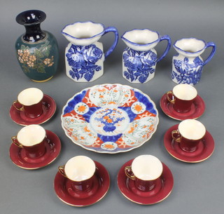 6 Crown Devon burgundy and gilt coffee cups and saucers, a set of 3 Victorian style graduated blue and white jugs, a Doulton vase and an Imari plate 