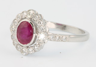 An 18ct white gold ruby and diamond oval cluster ring, the centre stone approx. 0.85ct surrounded by diamonds approx. 0.35ct, size P 1/2