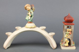 A Hummel 4 light candle holder surmounted by an angel 10 1/2", a ditto group of figures on a bell tower 11" 