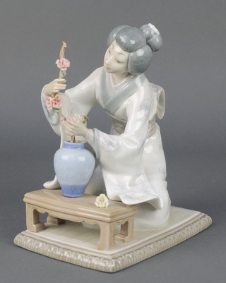 A Lladro figure of a Japanese lady kneeling before a table 8/28 7 1/2" 