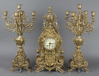 A Walt 20th Century clock garniture comprising striking mantel clock with enamelled dial contained in a pierced gilt metal case and a pair of 5 light candelabrum 
