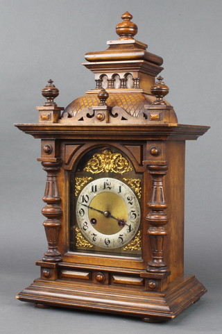 A 19th Century Continental striking bracket clock with arched dial and Arabic numerals contained in a walnut case 