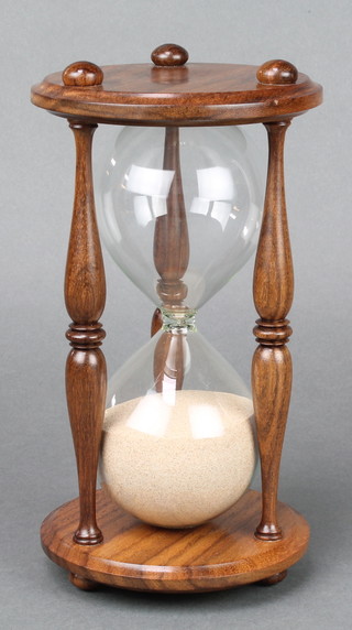 A reproduction glass and mahogany hour glass 9" 