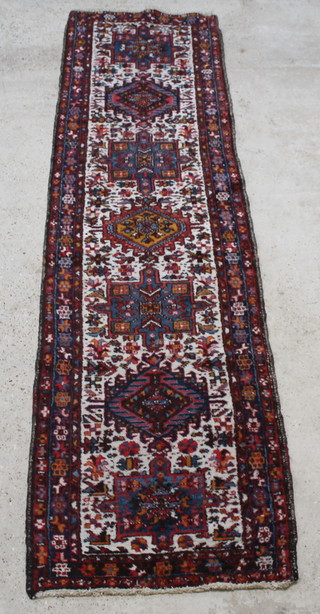 A blue, red and white ground Persian Heriz runner with 7 stylised medallions to the centre 131" x 35" 
