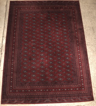 A red ground Bokhara style carpet with 114 octagons to the centre some staining in places 138" x 99" 