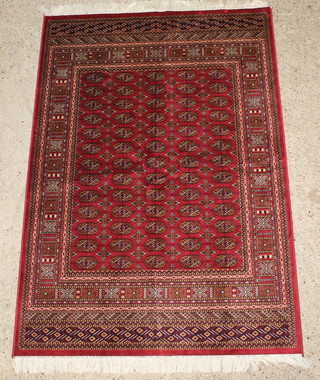 A red ground Bokhara style carpet with 65 octagons the centre 75" x 53" 