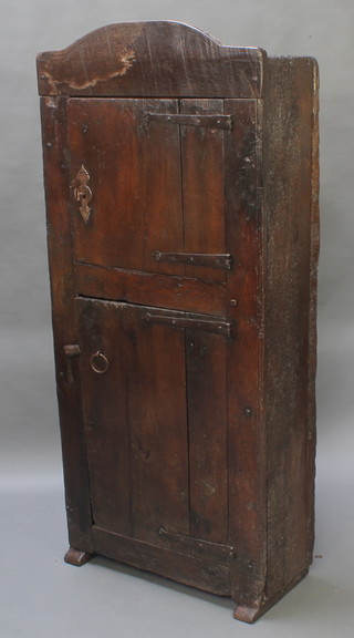 An antique double cupboard of arched form enclosed by panelled doors with iron hinges, constructed of old timber,  67h" x 30"w x 12"d 

