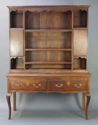 A Georgian oak dresser, the associated raised back with moulded cornice, fitted shelves flanked by a cupboard to either side, the base with 2 drawers, raised on cabriole supports 81"h x 60"w x 20"d 