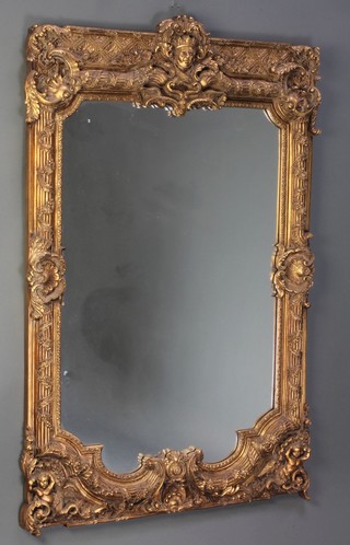 A rectangular plate wall mirror contained in a decorative ornate frame 49"h x 30"w 